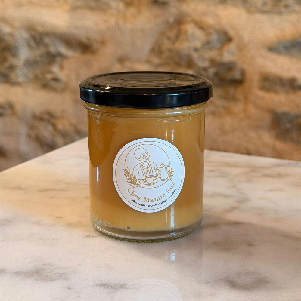 Pot de caramel au beurre salé artisanal de Chez Mamie Suz’, présenté sur un plan de travail en marbre
