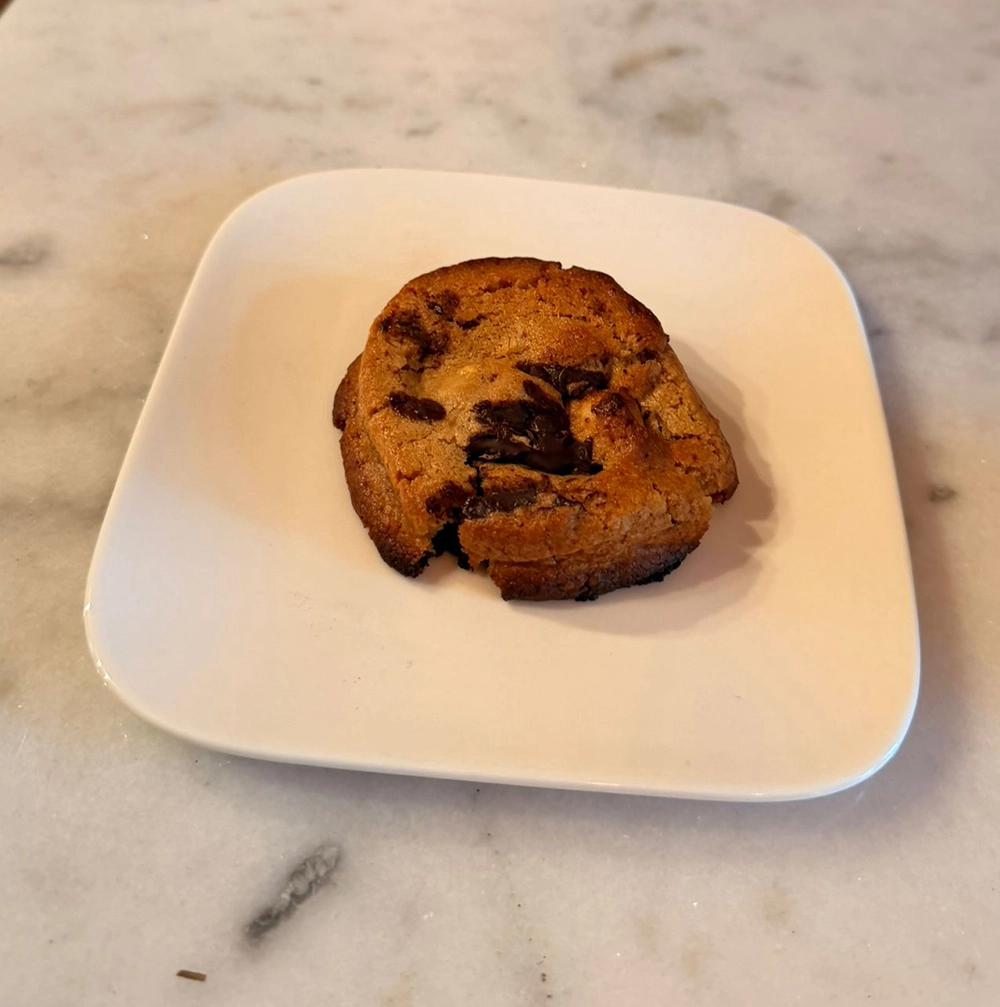 Cookie chocolat noisette légèrement croustillant, présenté sur une assiette blanche