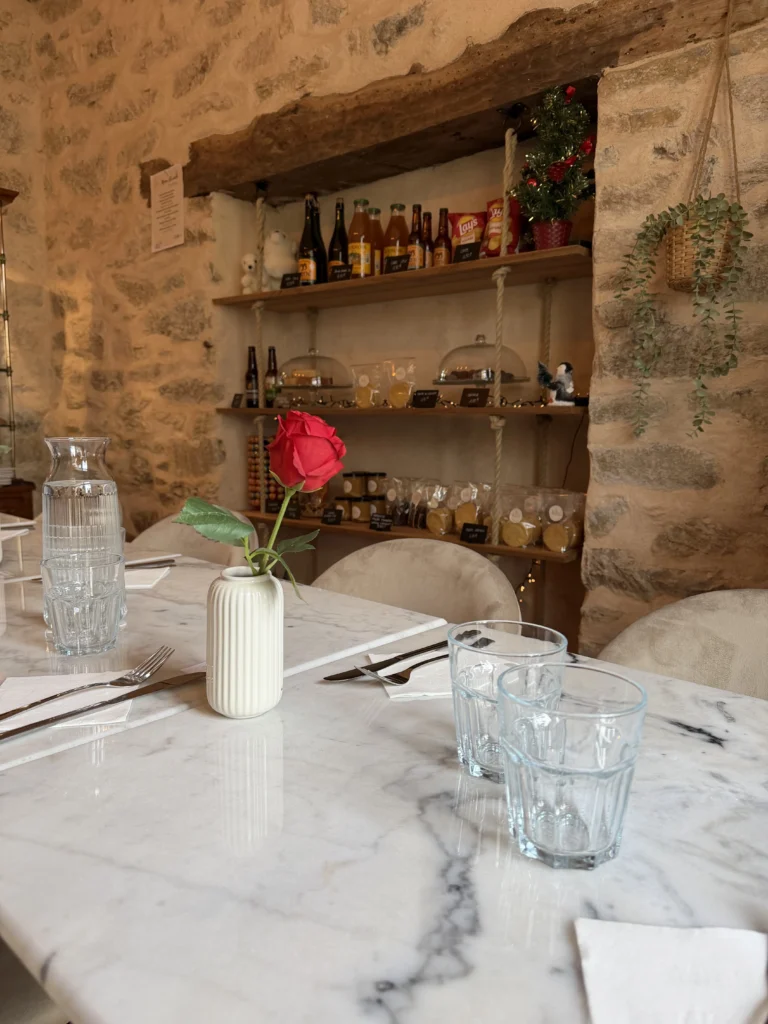 Table du salon de thé Chez Mamie Suz’ avec vaisselle et étagères en arrière-plan